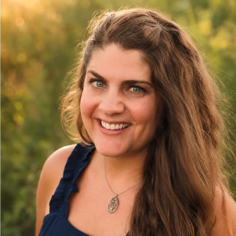 Portrait of Sarah, founder of Wild Moon Magik, smiling outdoors in a sunlit natural setting